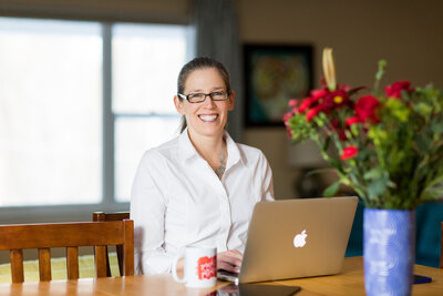 woman sitting on a couch looking at an ipad