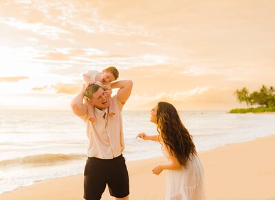 Family walks with child on the beach during family portrait photography session with Love + Water Maui