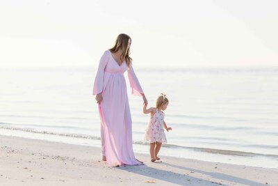 A mom walking with her daughter during her maternity photo shoot