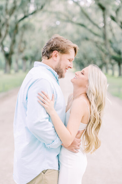 Couple embracing under trees with Spanish moss