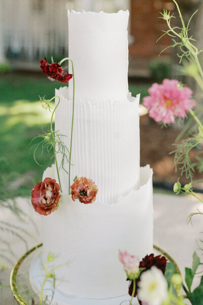white wedding cake with colorful flowers for decoration