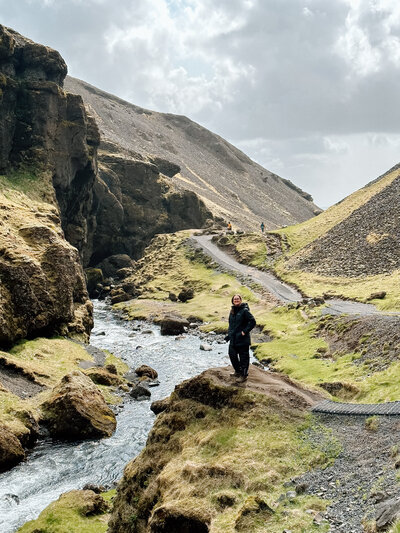 Desiree standing along a stream in Iceland.