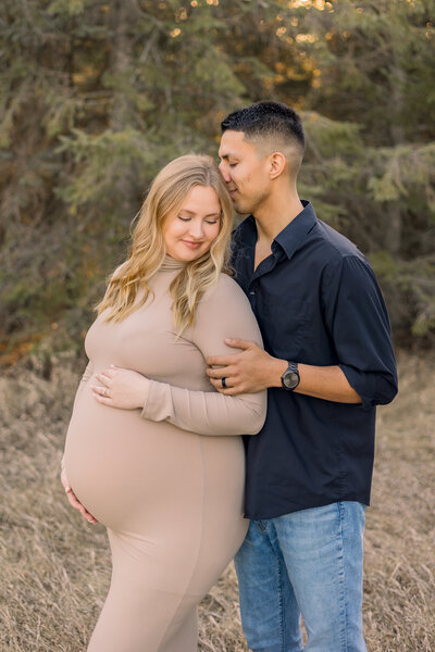 Future mom and dad during maternity photo session showing off baby bump