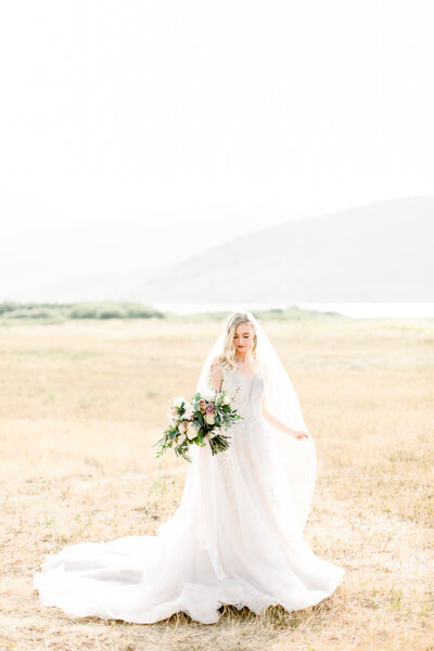 Bridal portrait in an open field during golden hour with a beautiful bouquet made by Over the top events based in Salt Lake City, Utah.