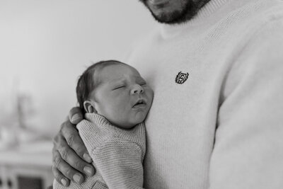 Dad comforting newborn son at family session in Chicago, IL