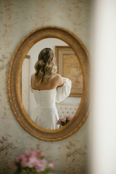 Bride enjoying a moment of self-care, looking at herself in the mirror before her wedding day in Columbus, Ohio.