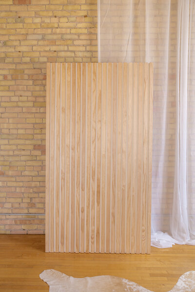 A seven foot tall wooden slat wall backdrop.