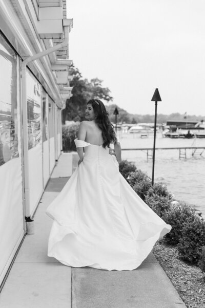 bride running along Gun Lake during their wedding photography michigan