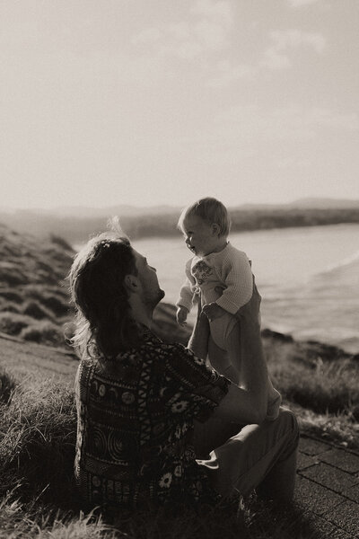 A film-like black and white image of a father and daughter on Boambee Headland in Sawtell during his family photo shoot by Coffs Harbour photographer Fire & Fly