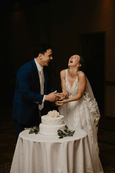 ecstatic couple cutting cake