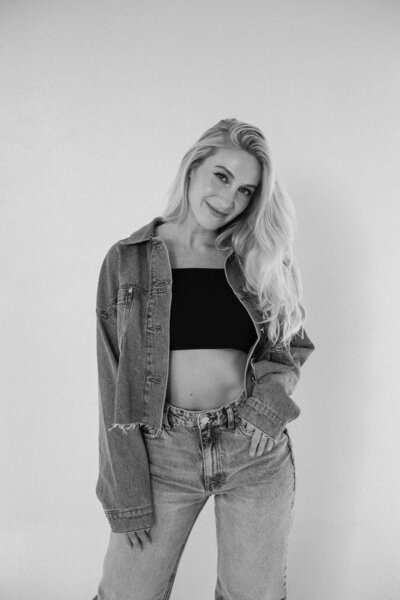 A girl in a brand photoshoot with her hand on her hip posing for the camera