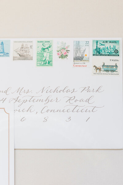 White wedding invitation envelope with taupe calligraphy and vintage postage stamps for Greenwich, Connecticut wedding