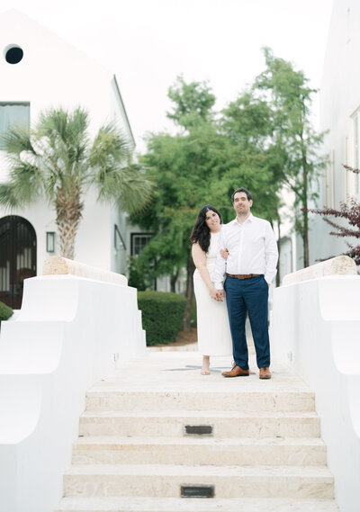 Engaged couple embracing against a column during their outdoor engagement session, captured in black and white by Nashville wedding photographer Diana Marie