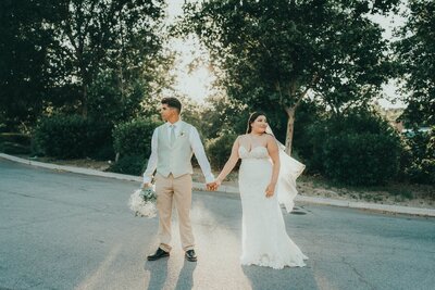 Young couple just married in Paso Robles, California, holding hands in a scenic outdoor setting.