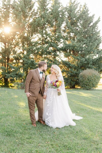 A bride and groom kissing with veil blowing in the wind