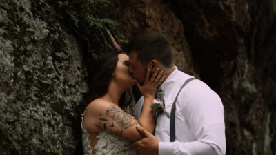 couple kissing in front of large rocks on private property outside of Pittsburgh pa