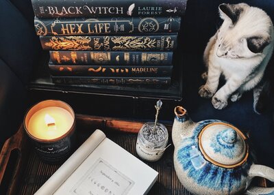 bookstack with candles, teapot, and kitten