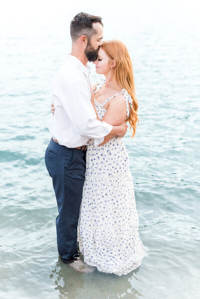 romantic couple in the ocean kissing for a unique engagement photo idea