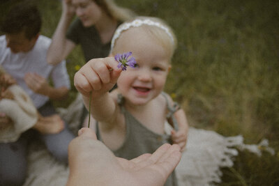 child holding a flower during a summer family photography session / en jente holder en blomster i en sommer familie fotografering. 