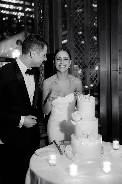 couple smiling next to cake
