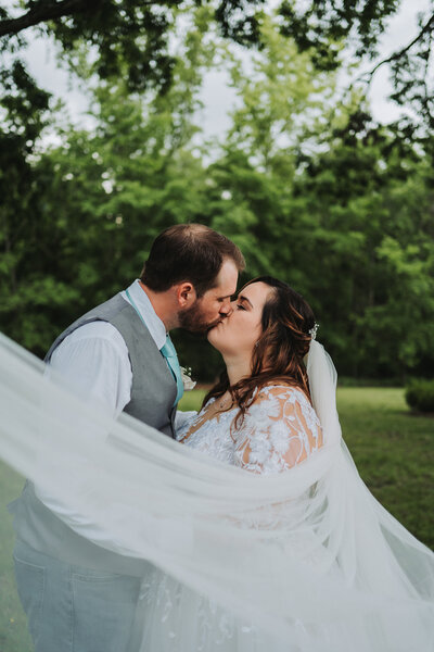 A romantic moment as the bride and groom share a loving kiss at the Michaux-St. James Foundation, beautifully captured by Quinn Photography LLC.