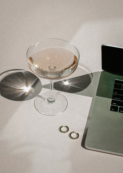 A glass is there in side of a laptop on a desk of online dating coach