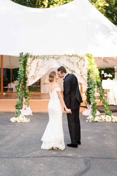 A bride and groom kiss before entering their tent wedding reception at the Rocky Fork Country Club