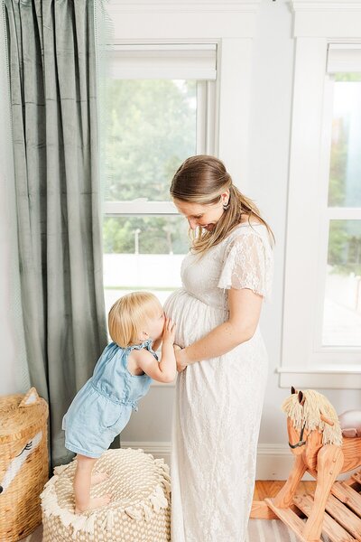 mother holds toddler during  maternity photo session with Sara Sniderman  Photography in Wellesley Massachuesetts