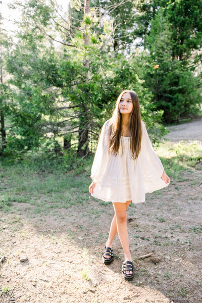 Senior shows off her white dress at her senior photos in Shaver Lake mountains