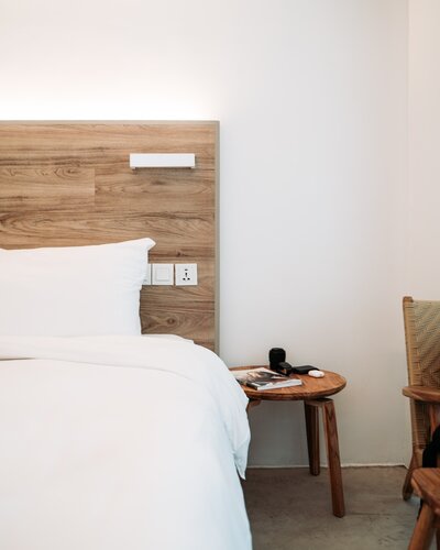 Minimal bed with fresh white linens and wood headboard