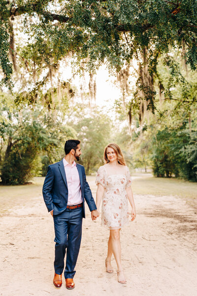 couple walking and holding hands during an engagement session
