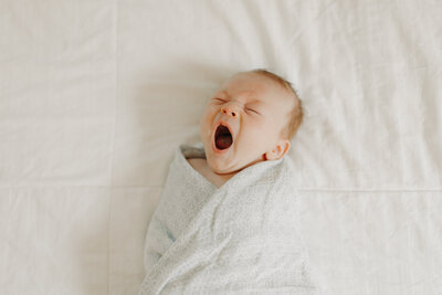 Infant boy yawning during newborn session in St. Louis, MO