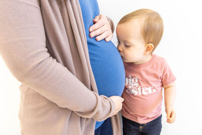 Baby kissing mothers pregnant belly