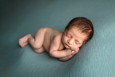 Newborn boy sleeping peacefully during his baby photo session in Minnesota.