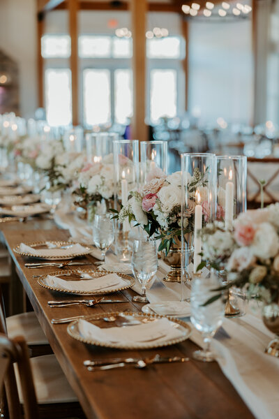 White and blush floral centerpieces with gold taper candles