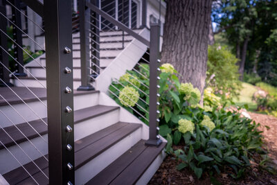 L-shaped deck staircase with contrasting stair risers and cable railing. 