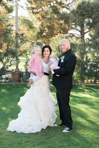 Bride and groom with their children in pink dresses