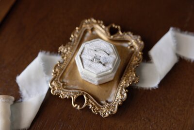 bride's engagement ring styled in velvet box on antique tray