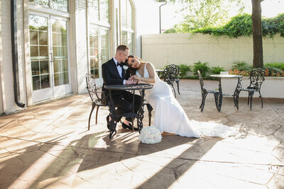 ride and groom sharing a quiet moment at an outdoor table at dallas, texas wedding venue
