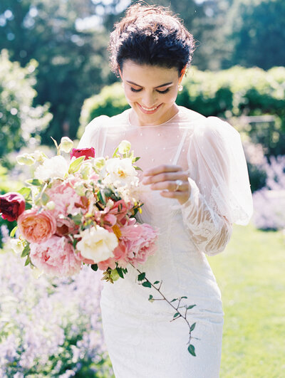 Bride holding a red and blush bridal bouquet