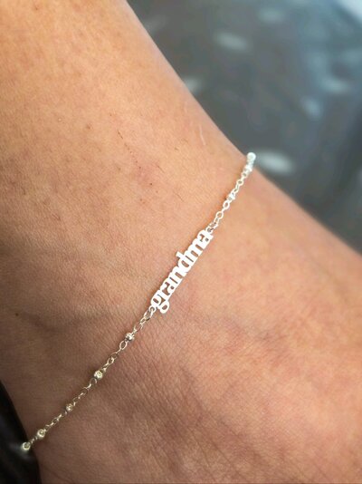 Custom silver permanent bracelet with 'Grandma' engraving, from Jazzy's Glam Bar.