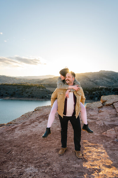 A man giving his girlfriend a piggyback ride above Horsetooth Reservoir in Fort Collins