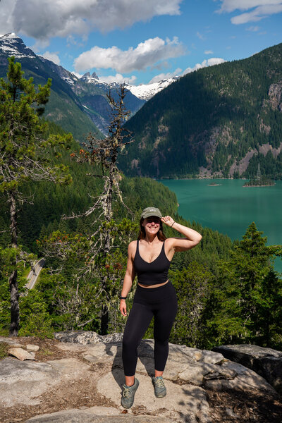 Woman wearing a black sports bra and leggings stands in front of Blue Lakes in Colorado.