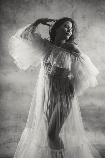 a black and white image of a woman in a gown at a vancouver boudoir photoshoot with gowns in Vancouver