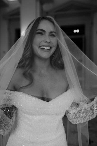 Bride smiling in beautiful dress under veil