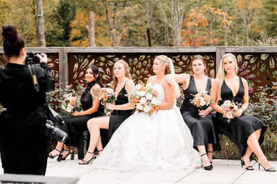 bts shot of photographer posing wedding bride and bridesmaids