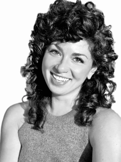 Black and white photo of woman with brown curly hair smiling at camera
