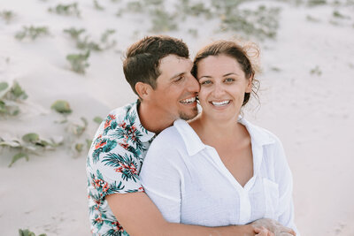 Engaged couple embracing in photos at beach session in Port Aransas Texas
