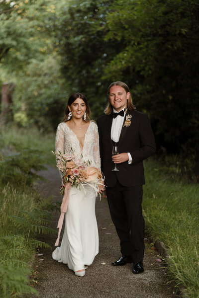 a bohemian bride and groom stood for a portrait on their wedding day in a tropical location