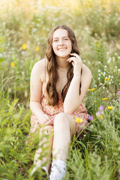 Girl sitting in a field of flowers.